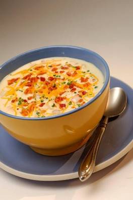 Disney's Loaded Baked Potato Soup

Serves 6

1 pound bacon, roughly chopped
 1 medium yellow onion, diced
 1 large carrot, peeled and diced
 3/4 cup diced celery
 4 large Russet potatoes, peeled and diced
 4 medium red potatoes, diced
 1/4 cup flour
 2 cups chicken or vegetable stock
 Coarse salt, freshly ground pepper, to taste
 4 cups heavy whipping cream
 Optional garnishes: chopped chives, bacon bits, sour cream, shredded cheddar and Monterey Jack cheese
1.In a 6- to 8-quart stockpot over medium heat, fry bacon until crisp.
2.Remove bacon and drain on paper towels, reserving half for garnish. In bacon fat, cook onions, carrots, and celery until the onions are translucent. Add potatoes and cook for 4 minutes, stirring occasionally.
3.Whisk in flour and stir constantly over low heat until the flour is cooked and the mixture has thickened slightly, about 5 to 7 minutes. Add chicken stock and half of the bacon. Season with salt and pepper.
4.Over medium-high heat, bring the soup to a simmer and cook for 25 minutes or until the potatoes are soft. Mash some of the potatoes for thicker, creamier texture. Add whipping cream and simmer for 5 minutes.
5.Adjust thickness by adding water or stock. Soup should have a creamy consistency.
6.Season to taste, and garnish with toppings.

Cooks’ notes: Soak diced potatoes in cold water until ready to use to keep them from turning brown. To make bacon easier to chop, lightly freeze.
 
disneyparks.disney.go.com