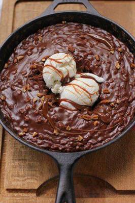 Gooey Chocolate Skillet Cake Ice Cream Sundae

1 cup flour
1/2 teaspoon baking soda
1 cup sugar
dash salt
1/4 cup (1/2 stick) butter
1/4 cup vegetable oil
2 tablespoons cocoa powder
1/2 cup water
1/4 cup buttermilk
1 egg
1/2 teaspoon vanilla

Frosting:
1/4 cup (1/2 stick) butter
2 tablespoons cocoa
3-4 tablespoons milk (as needed for consistency)
1/2 cup pecans, chopped
2 cups powdered sugar
1/2 teaspoon vanilla
ice cream (for serving)
caramel sauce (for serving; this one is delicious!)
whipped cream (for serving)

Preheat the oven to 350 degrees F. In a large bowl, whisk flour, baking soda, sugar, and salt together and set aside. 

In a 10-inch cast iron skillet, bring the butter, vegetable oil, cocoa powder, and water to a boil. Remove it from the heat and whisk in the dry ingredients well. Mix in the buttermilk, egg, and vanilla. Bake the skillet cake at 350 degrees F for about 15-20 minutes or until a toothpick comes out with just a few moist crumbs. 

While the cake starts to cool, make the frosting. In a medium saucepan, bring the butter, cocoa, and milk to a boil. Remove them from heat and add the icing sugar, nuts, and vanilla. Stir to combine. Pour over the warm cake, spread with a spatula, and serve with vanilla bean ice cream, caramel sauce, and whipped cream.