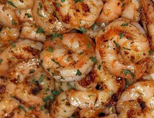 Ruth's Chris New Orleans-Style BBQ Shrimp

Ingredients:
-Makes 4 servings
-20 large (16/20) shrimp, peeled and deveined
-1 ounce canola oil
-1 tablespoon plus 5 teaspoons green onions, chopped
-2 ounces dry white wine
-1 teaspoon fresh chopped garlic
-4 tablespoons Lea & Perrins Worcestershire Sauce
-1 teaspoon Tabasco
-1/2 teaspoon cayenne
-1/2 teaspoon paprika
-8 ounces (2 sticks) salted butter

Directions:
Place a large cast iron skillet on a burner and heat over high heat. Add oil and cook shrimp until they are just done. It's best to prepare shrimp in batches if you do not have large skillet. Remove shrimp and set aside on a large platter.

Add green onions to the oil in the skillet and cook for 1 minute. Add white wine and let simmer until it is reduced by half.

When the wine is reduced by half, add chopped garlic, Worcestershire, Tabasco. cayenne pepper and paprika. Shake the pan well and cook for 1 minute. Reduce the heat to low.

Cut butter into small chunks with the knife and slowly add into pan, shaking fast to melt butter.

Continue to add butter and shake until all butter is melted. Add shrimp back to pan and toss well to coat shrimp with butter and seasonings and to heat the shrimp. Place shrimp on four plates and enjoy.